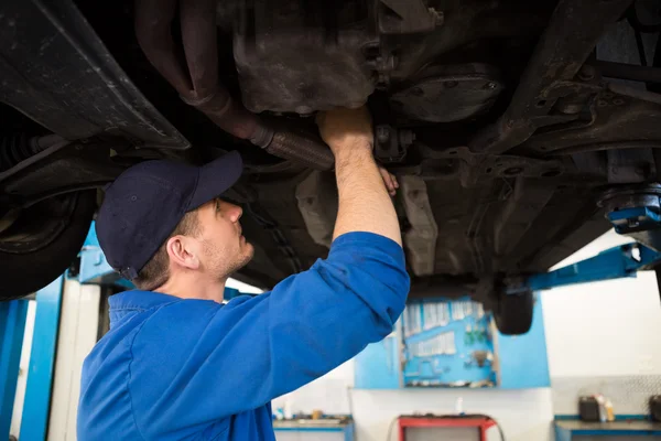 Mechaniker untersucht unter dem Auto — Stockfoto