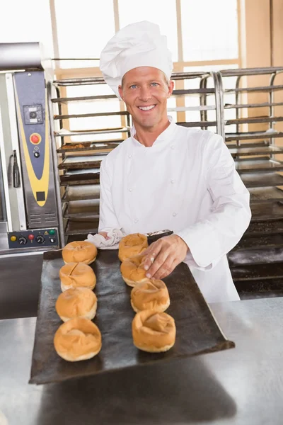 Baker holding tray of fresh bread — Stock Photo, Image