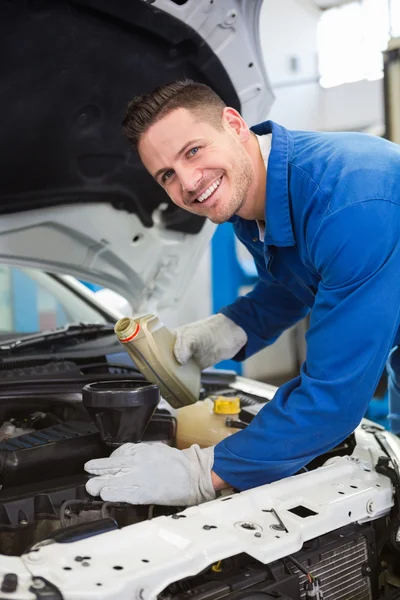 Mechanic pouring oil into car — Stock Photo, Image