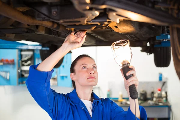 Mekaniker lyste ficklampa under bil — Stockfoto