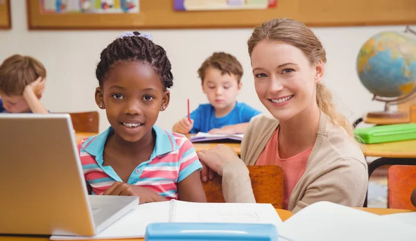 Cute pupil using computer with teacher — Stock Photo, Image