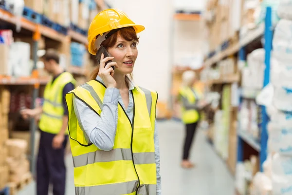 Warehouse manager talking on the phone looking around — Stock Photo, Image