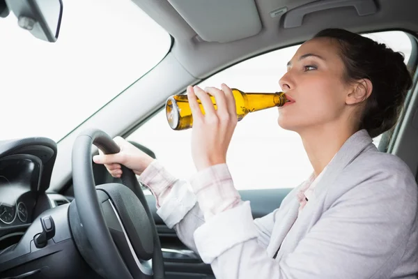 Woman drinking beer while driving — Stock Photo, Image