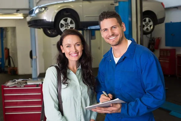 Mechanic smiling with customer — Stock Photo, Image