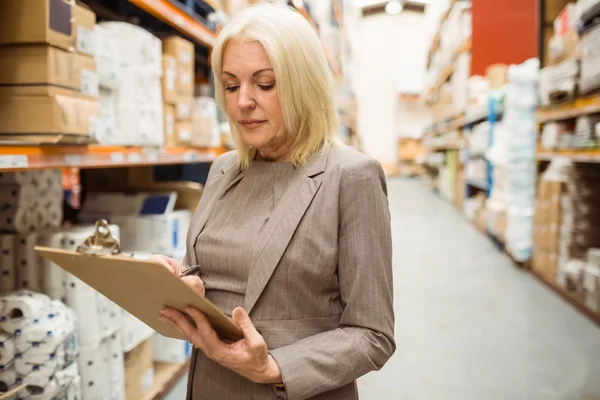 Focused female manager holding clipboard — Stock Photo, Image