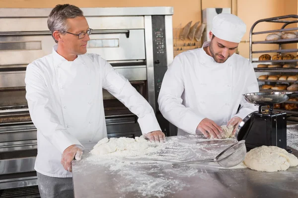 Bäcker schaut seinem Kollegen beim Teigkneten zu — Stockfoto