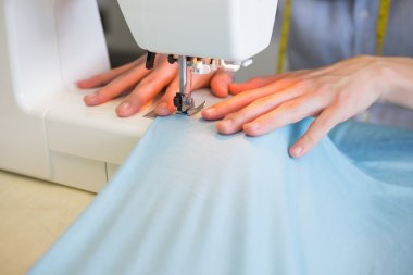 Close up of student using sewing machine clipart