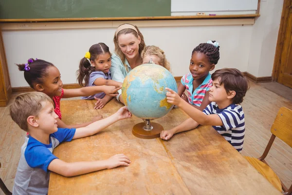 Lindos alumnos y profesor en el aula con globo — Foto de Stock