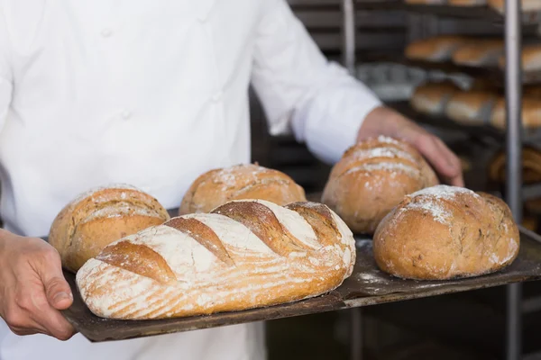 Baker bedrijf lade van brood — Stockfoto