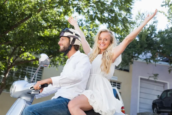 Attractive couple riding a scooter — Stock Photo, Image