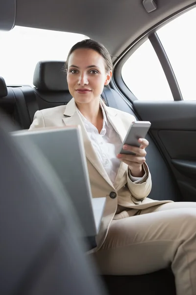 Pretty businesswoman working in the back seat — Stock Photo, Image