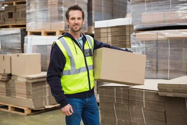 Arbeiter trägt Karton im Lager — Stockfoto