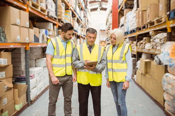 Gerente escribiendo en portapapeles hablando con colega — Foto de Stock