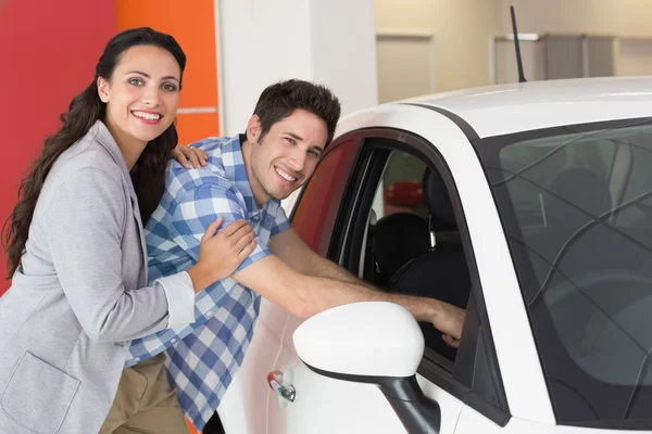 Pareja sonriente mirando dentro de un coche —  Fotos de Stock