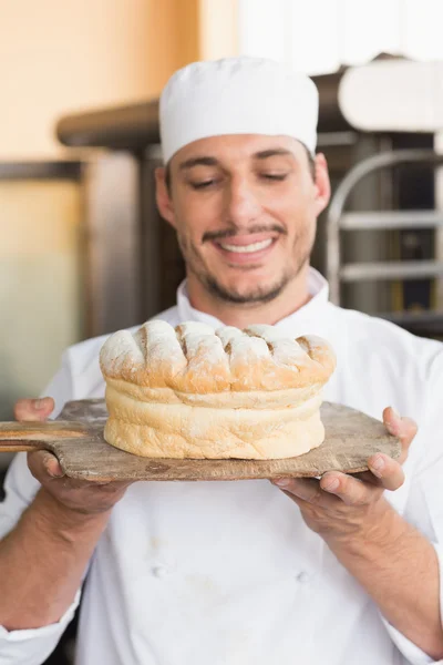 Taze pişmiş ekmek gösterilen Baker — Stok fotoğraf