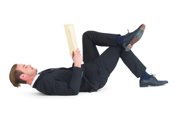 Relajado hombre de negocios mintiendo y leyendo libro — Foto de Stock