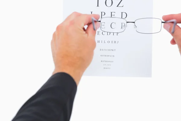 Homem segurando óculos sobre papel — Fotografia de Stock