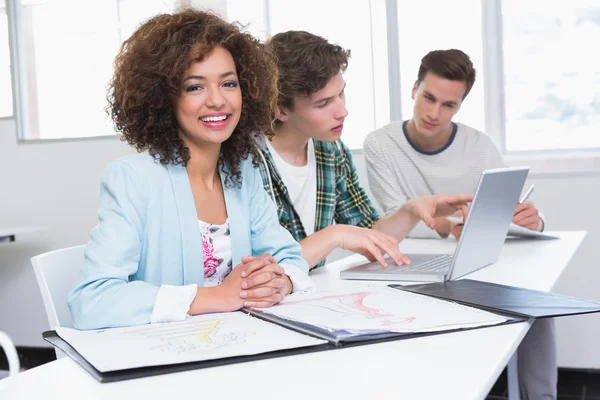 Students working together with laptop and pictures — Stock Photo, Image