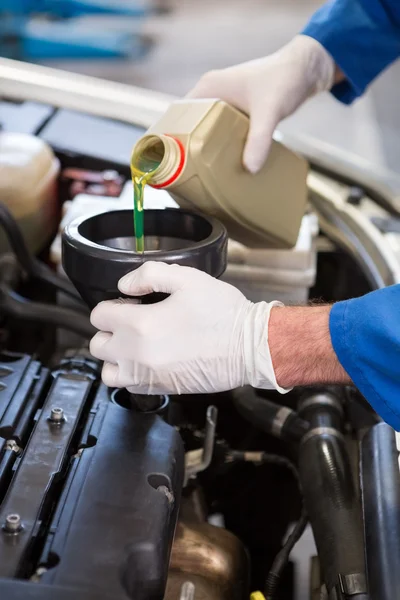 Mechanic pouring oil into car — Stock Photo, Image