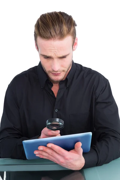 Uomo d'affari guardando tablet con lente d'ingrandimento — Foto Stock