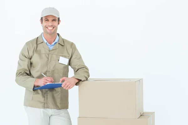 Delivery man writing on clipboar — Stock Photo, Image