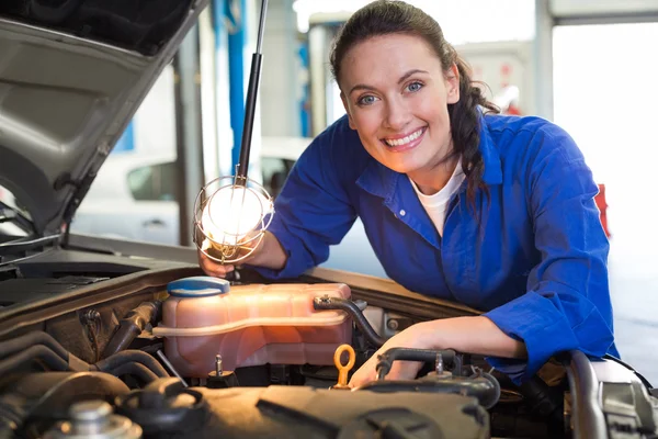 Mechanic smiling at the camera with torch — Stock Photo, Image