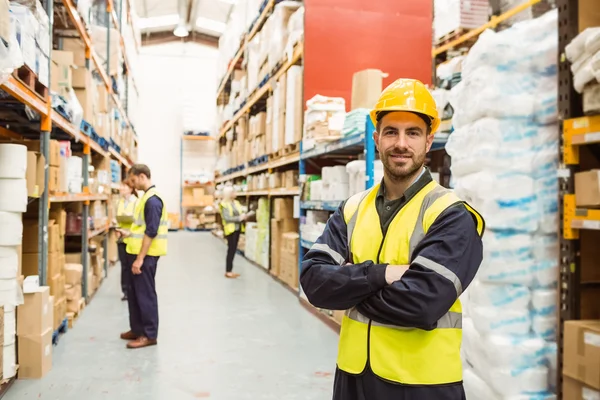 Leende arbetstagaren bär gul väst med armarna korsade — Stockfoto