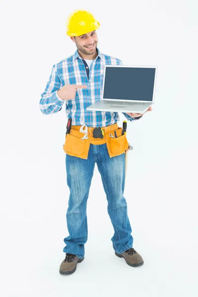 Construction worker pointing at laptop — Stock Photo, Image