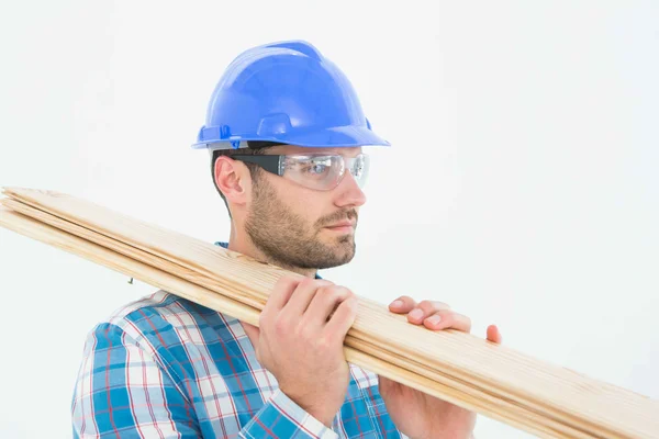 Confident carpenter carrying wooden planks — Stock Photo, Image