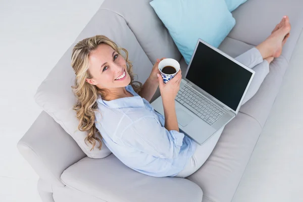 Lachende blond met laptop een koffie — Stockfoto
