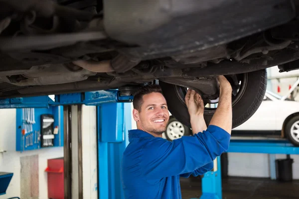 Smiling mechanic adjusting the tire wheel — Stock Photo, Image