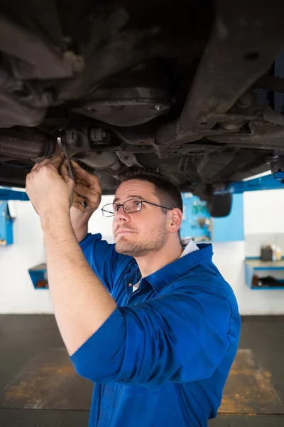 Mechaniker untersucht unter dem Auto — Stockfoto