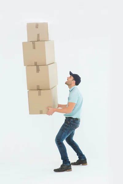 Shocked delivery man carrying stack of boxes — Stock Photo, Image