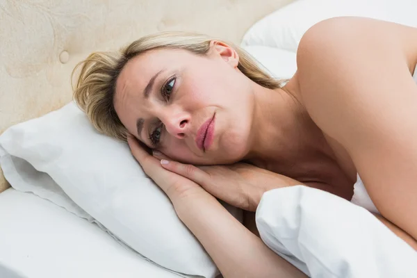 Thoughtful blonde lying in bed — Stock Photo, Image