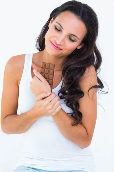 Pretty brunette eating bar of chocolate — Stock Photo, Image