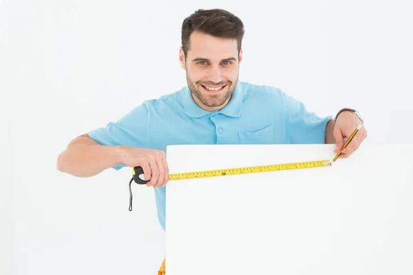 Happy worker measuring blank billboard — Stock Photo, Image