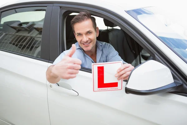 Männlicher Fahrer gibt Daumen hoch, während er sein L-Zeichen hält — Stockfoto