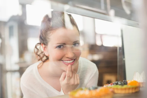 Mooie brunette kijken naar taarten — Stockfoto