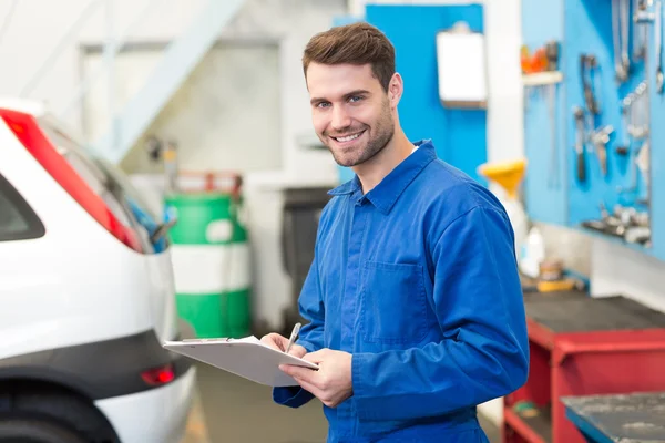 Mechanic writing on a clipboard — Stock Photo, Image