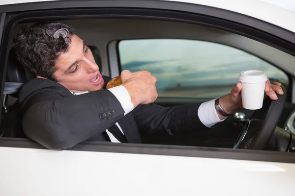 Mann trinkt Kaffee und isst Donut — Stockfoto