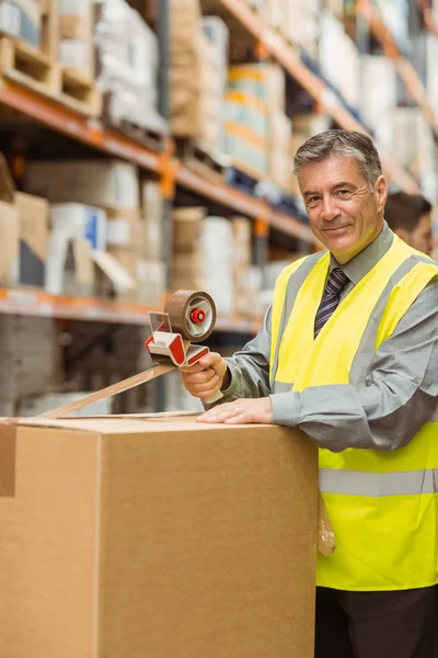 Warehouse worker sealing cardboard boxes for shipping — Stock Photo, Image