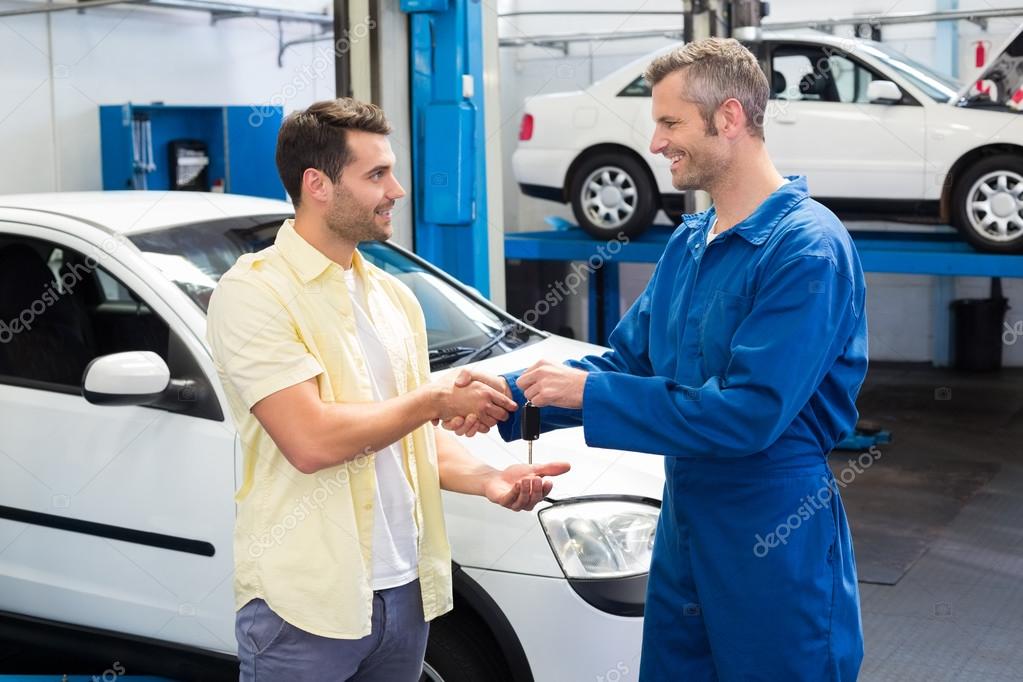 Customer shaking hands with mechanic Stock Photo by ©Wavebreakmedia