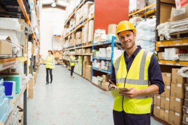 Warehouse worker smiling at camera with clipboard clipart