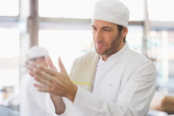 Baker batendo palmas de farinha de suas mãos — Fotografia de Stock