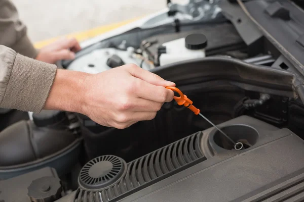 Man using dipstick to check oil — Stock Photo, Image