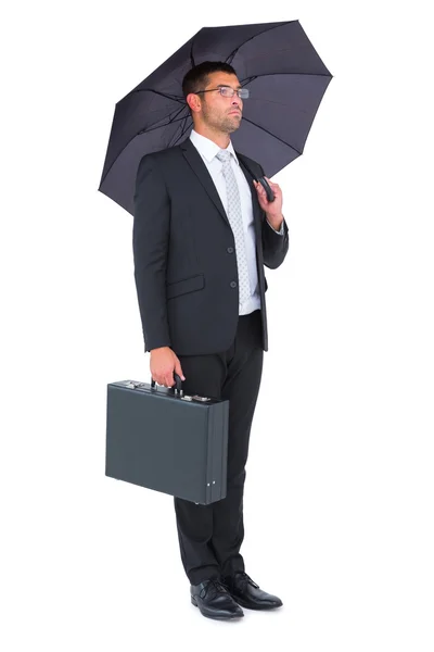 Empresario refugiándose bajo paraguas bllack — Foto de Stock