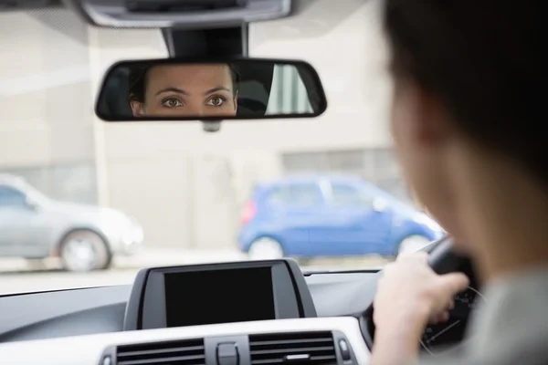 Femme conduisant avec son reflet dans le miroir — Photo