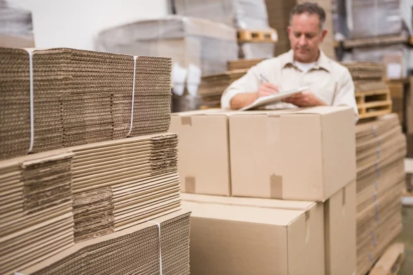Warehouse worker checking his list — Stock Photo, Image