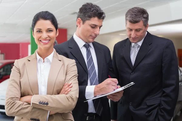 Empresário escrevendo na área de transferência conversando com colega — Fotografia de Stock