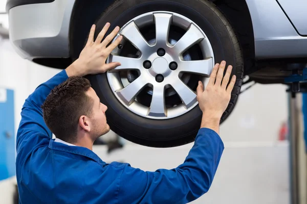 Mechanic adjusting the tire wheel — Stock Photo, Image